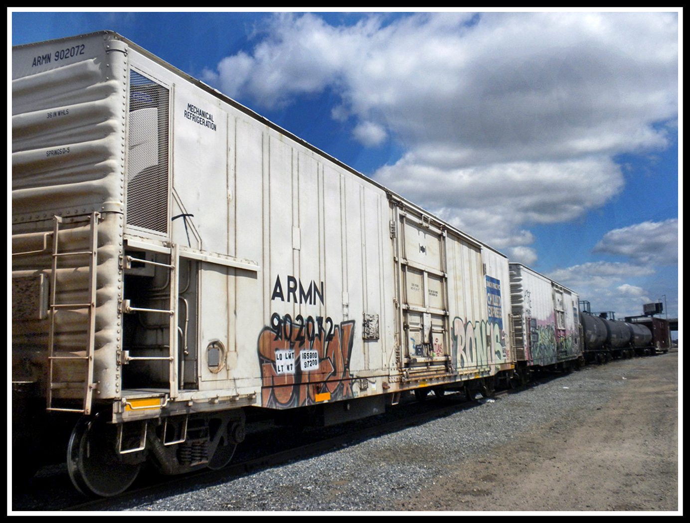 Graffiti on white cars and 3 black tanks by Shirley Ward